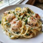 A close-up of creamy Garlic Butter Shrimp Pasta topped with sautéed shrimp and fresh parsley.
