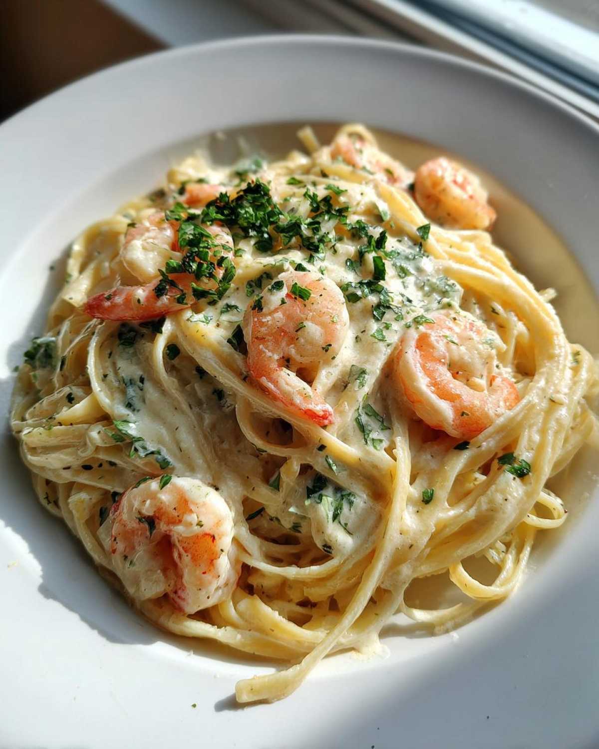 Close-up of Garlic Butter Shrimp Pasta with Cream Sauce, topped with fresh parsley.