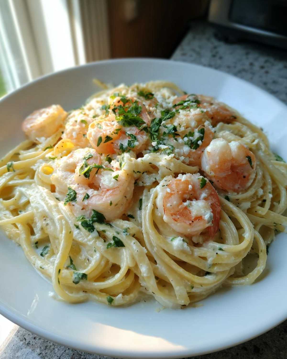 A close-up of rich Garlic Butter Shrimp Pasta with Cream Sauce, topped with shrimp and fresh parsley.