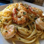 A close-up of creamy Garlic Butter Shrimp Pasta with large, pink shrimp seasoned with parsley.