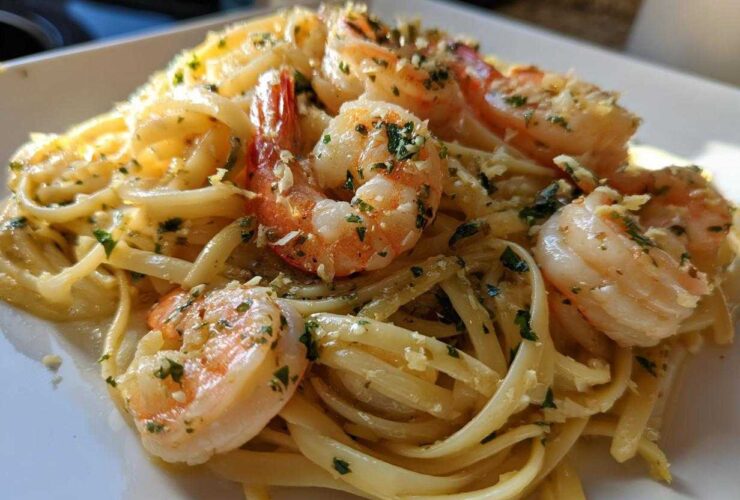 A close-up of creamy Garlic Butter Shrimp Pasta with large, pink shrimp seasoned with parsley.