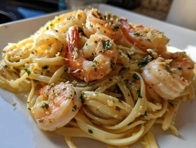 A close-up of creamy Garlic Butter Shrimp Pasta with large, pink shrimp seasoned with parsley.