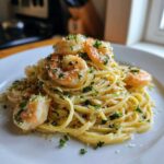 A close-up of a plate piled high with Garlic Butter Shrimp Pasta with Lemon Flavor, topped with shrimp and fresh parsley.