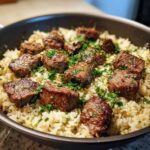 Close-up of Garlic Butter Steak and Rice Skillet Dinner, featuring seared steak bites over buttery rice topped with parsley.