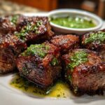 Close-up of perfectly seared Garlic Butter Steak Bites topped with bright green herb sauce.