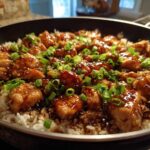 Close-up of Honey Garlic Chicken Skillet with Rice, topped with green onions and sesame seeds.