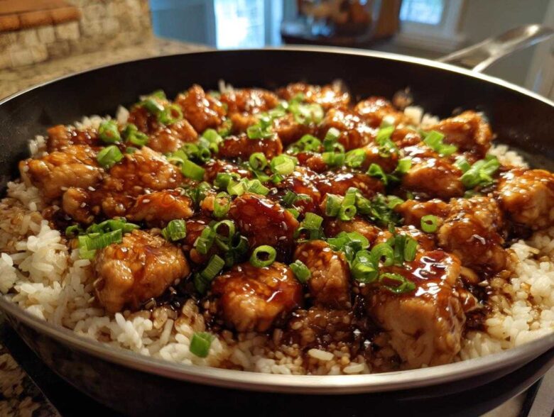 Close-up of Honey Garlic Chicken Skillet with Rice, topped with green onions and sesame seeds.
