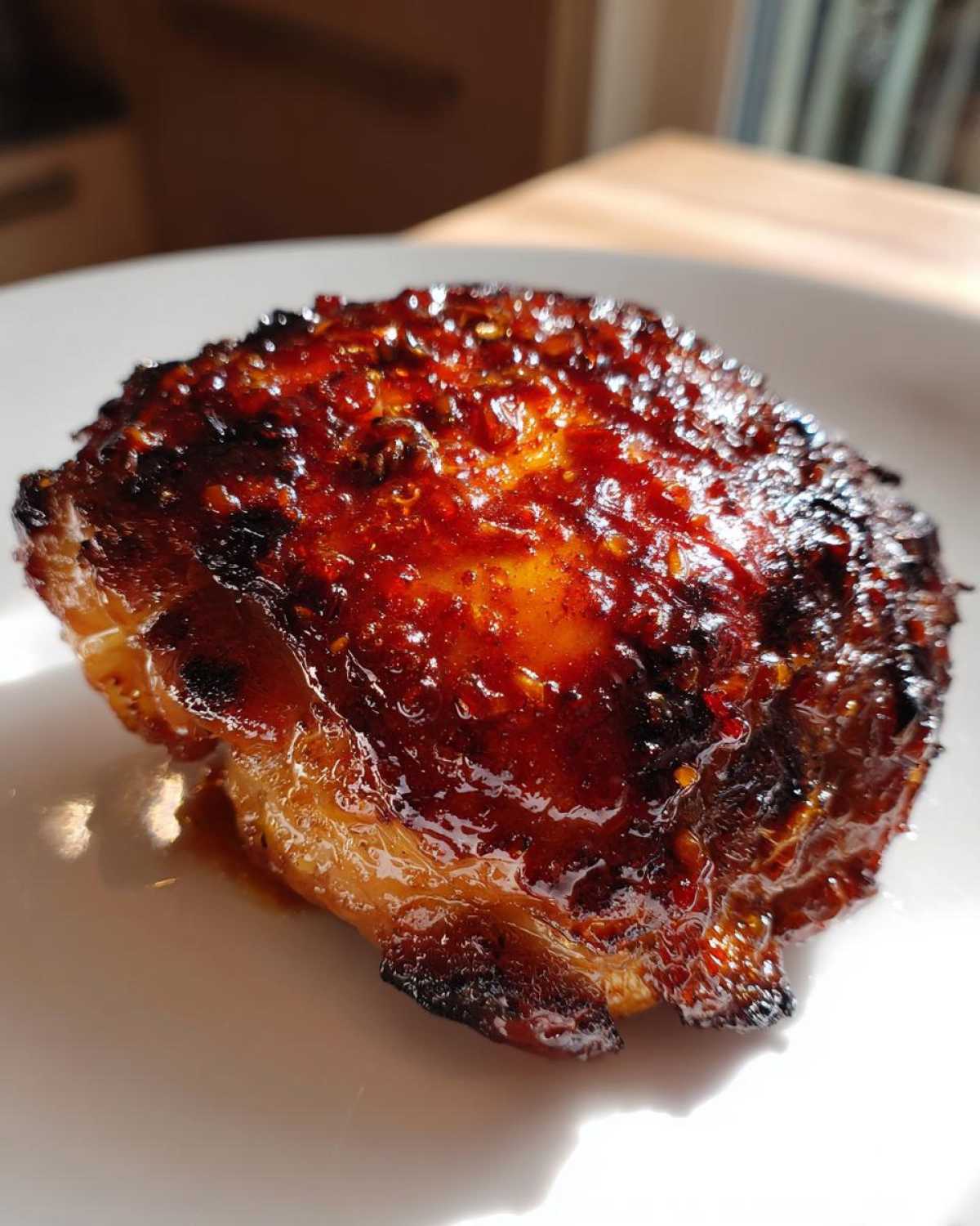 Close-up of a perfectly glazed Honey Garlic Chicken Thighs with crispy, caramelized skin.