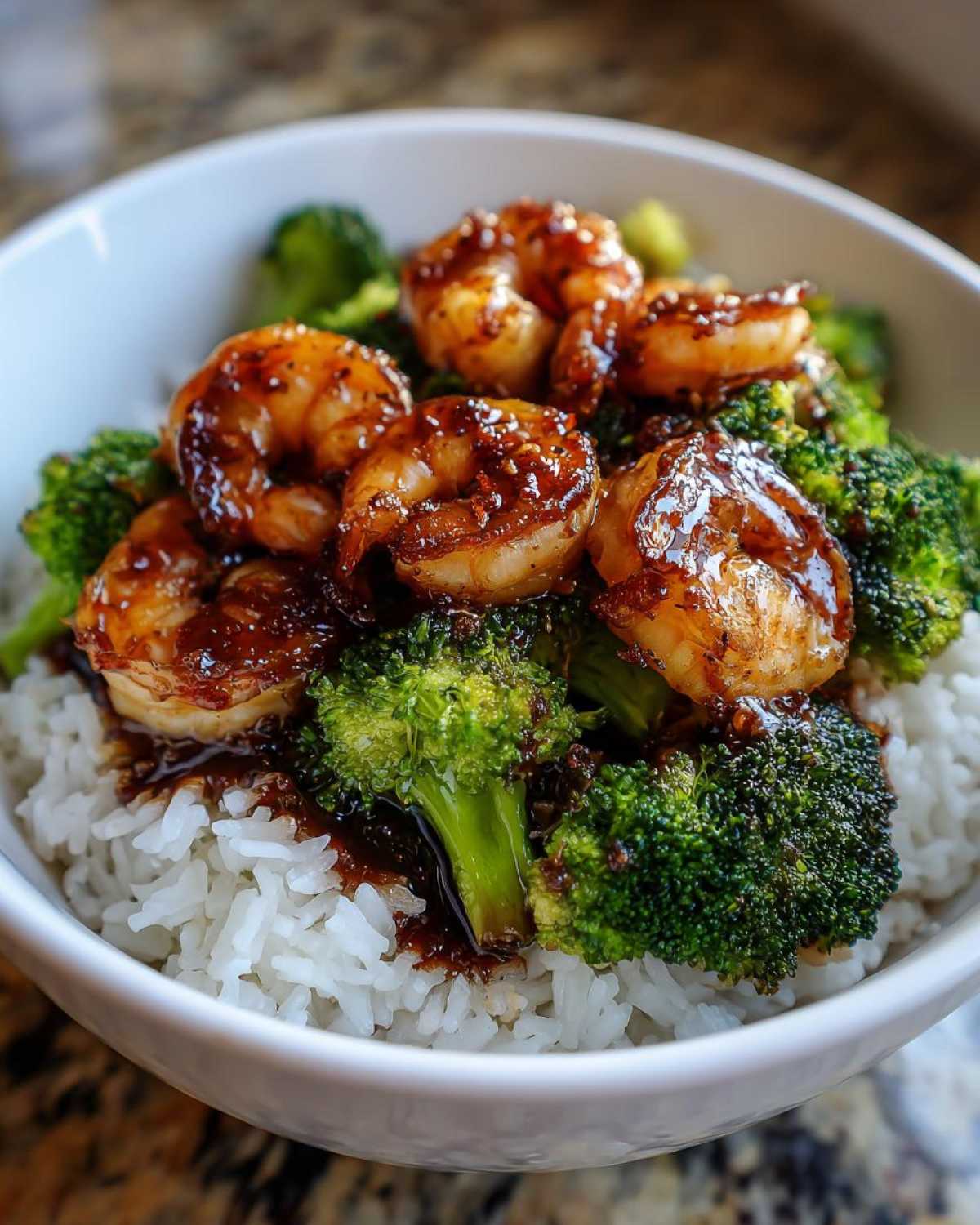 Close-up of a Honey Garlic Shrimp Bowl with glazed shrimp, bright green broccoli, and white rice.