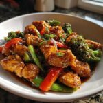 Close-up of Honey Soy Chicken Skillet with Veggies, featuring glazed chicken pieces, broccoli, and red peppers.
