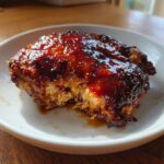 Close-up of a perfectly cooked Honey Soy Chicken Thighs with crispy, dark edges and a thick, shiny glaze.
