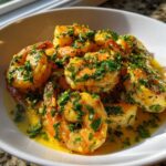 Close-up of succulent shrimp coated in bright yellow lemon butter sauce and fresh parsley, showcasing the Lemon Butter Shrimp with Garlic Flavor.