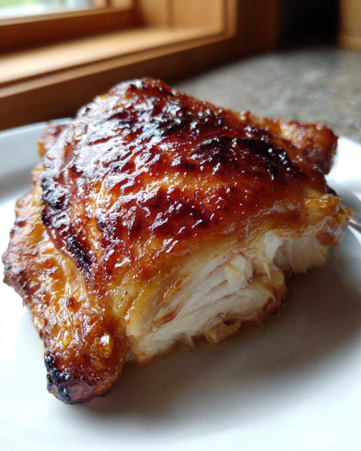 Close-up of a perfectly cooked Maple Dijon Chicken Thighs with a shiny, caramelized glaze.