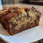 Close-up of three moist slices of Chocolate Chip Banana Bread on a white plate.