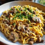 Close-up of creamy One Pan Ground Beef Stroganoff served over noodles, topped with mushrooms and fresh parsley.