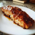 Close-up of a perfectly cooked salmon fillet topped generously with a thick Brown Sugar Teriyaki Salmon Glaze.