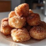 A close-up of a stack of Soft & Sweet Cinnamon Sugar Biscuit Bites coated heavily in cinnamon sugar.