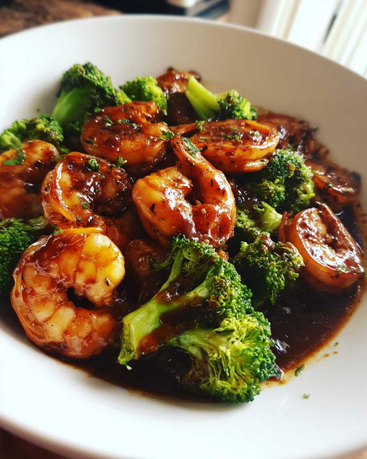 Close-up of Sticky Teriyaki Shrimp Stir Fry Quick Meal featuring plump shrimp coated in dark sauce alongside bright green broccoli florets.