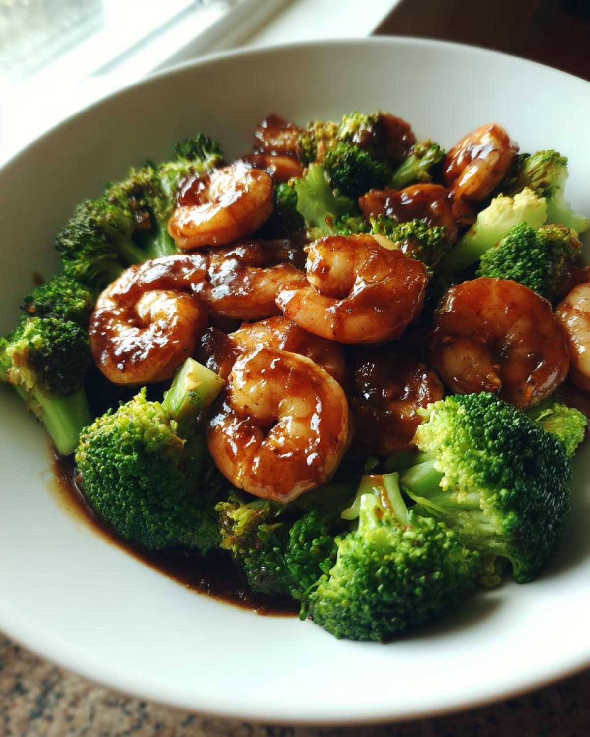 Close-up of Sticky Teriyaki Shrimp Stir Fry Quick Meal featuring glossy shrimp coated in sauce and bright green broccoli florets.