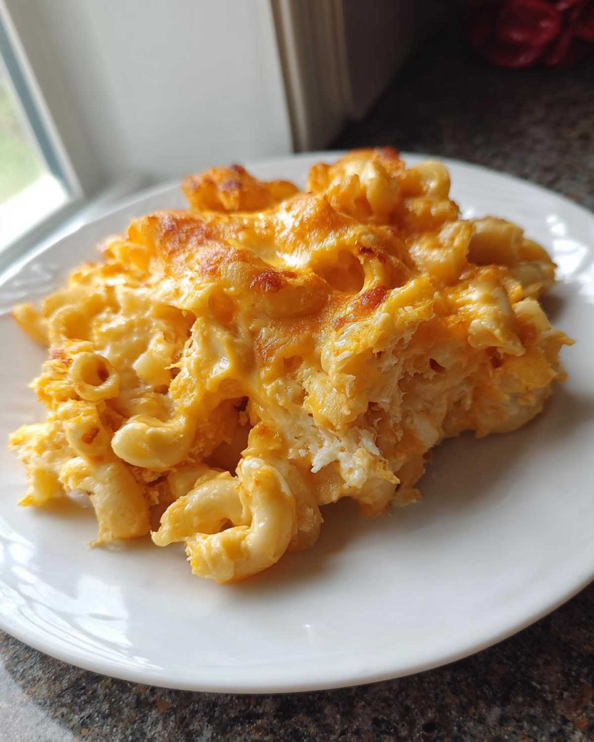 A generous serving of baked Chick-fil-A Mac and Cheese with a golden, slightly browned cheese crust on a white plate.