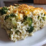 A square serving of creamy Chickpea Broccoli Rice Casserole Vegan Meal with a golden, cheesy top.