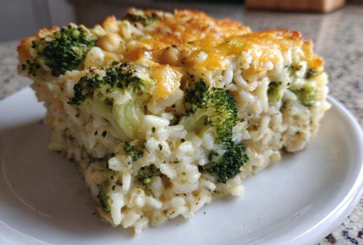 A square serving of creamy Chickpea Broccoli Rice Casserole Vegan Meal with a golden, cheesy top.