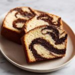 Three slices of light and dark swirled Coffee Marble Cookies arranged on a speckled plate.