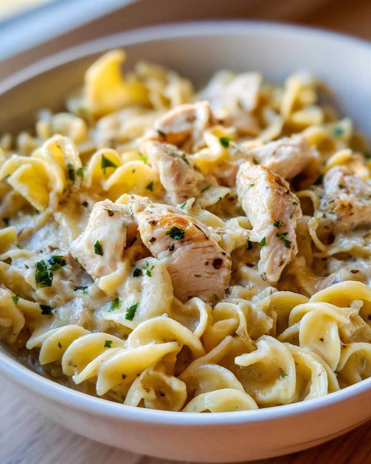 Close-up of creamy One Pot Chicken and Noodles featuring egg noodles and chunks of seasoned chicken breast.