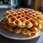 A stack of golden brown, fluffy Belgian waffles fresh off the iron, showcasing the perfect texture achieved with The Fluffiest Belgian Waffle Batter.
