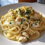 Close-up of Fresh Lemon Chicken Pasta featuring linguine tossed in a creamy sauce, topped with diced chicken, parsley, and bright lemon zest.