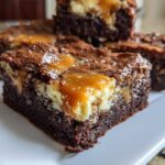 Close-up of fudgy Gluten Free Cheesecake Brownies topped with caramel sauce and sea salt.