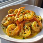 A white bowl filled with succulent Lemon Garlic Shrimp coated in a rich, buttery sauce and garnished with fresh parsley.