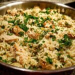 Close-up of the One Pan Garlic Butter Chicken Rice Skillet garnished with fresh parsley.