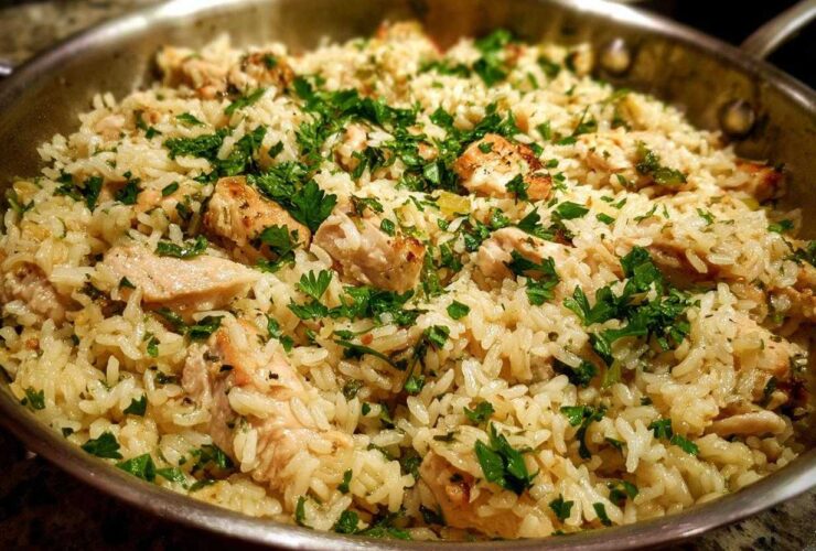 Close-up of the One Pan Garlic Butter Chicken Rice Skillet garnished with fresh parsley.
