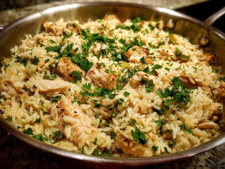 Close-up of the One Pan Garlic Butter Chicken Rice Skillet garnished with fresh parsley.