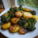 Close-up of golden Roasted Parmesan Potatoes and Broccoli served on a white plate.