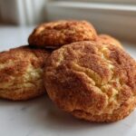 A close-up photo of several soft, puffy Snickerdoodle Cookies generously coated in cinnamon sugar.