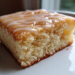 Close-up of a moist square slice of Starbucks Lemon Loaf Browned Butter Blondie topped with a white lemon glaze drizzle.