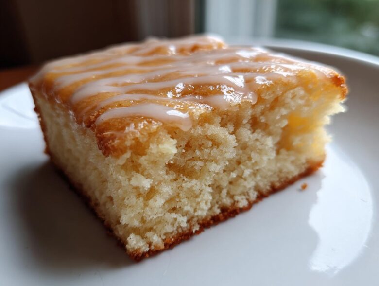 Close-up of a moist square slice of Starbucks Lemon Loaf Browned Butter Blondie topped with a white lemon glaze drizzle.
